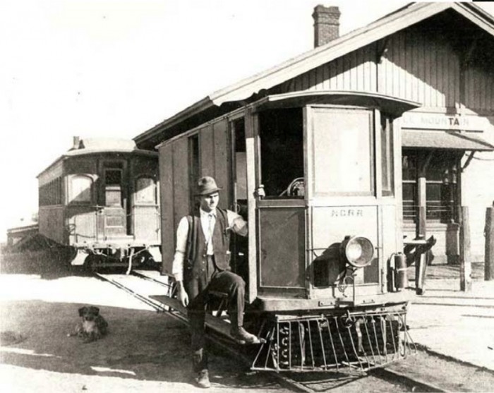 A motorman and his dog pose with Nevada Central Railroad No. 102 at the Battle Mountain Depot